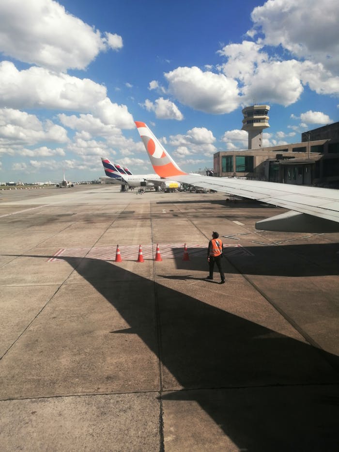View from an airplane window overlooking São Paulo airport with a control tower and aircraft.
